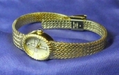 Sarah Coventry ladies watch, with cross, gold color with clear stones, new battery.
